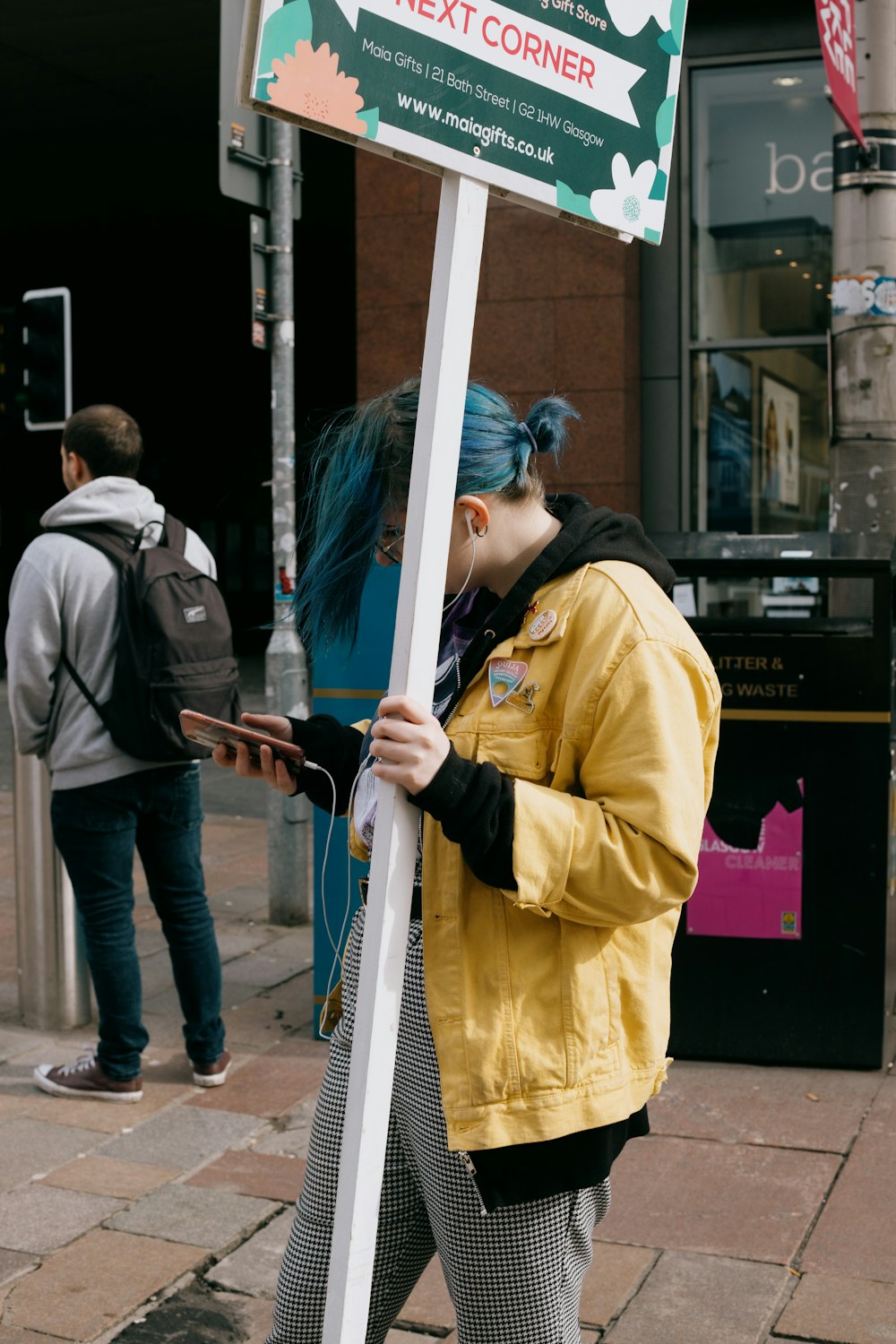 Mann in gelber Jacke mit weißer Metallstange