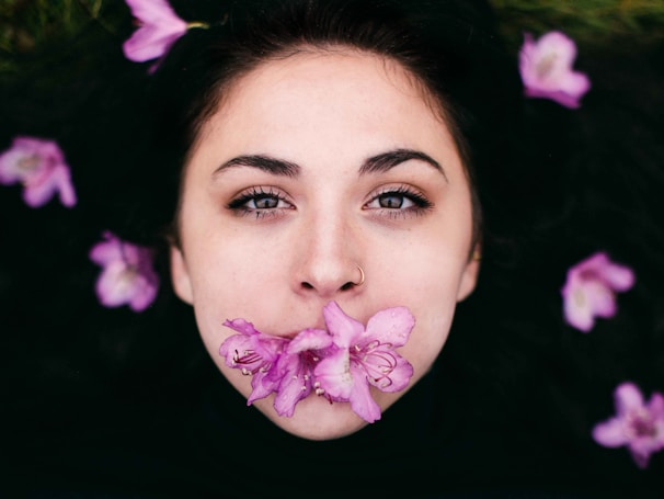 Soft-lit photo of a fresh nose piercing with a subtle white and yellow floral background
