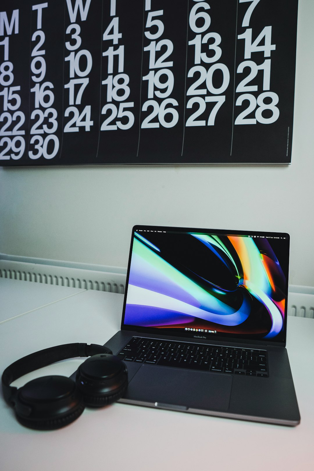 black laptop computer turned on beside black headphones