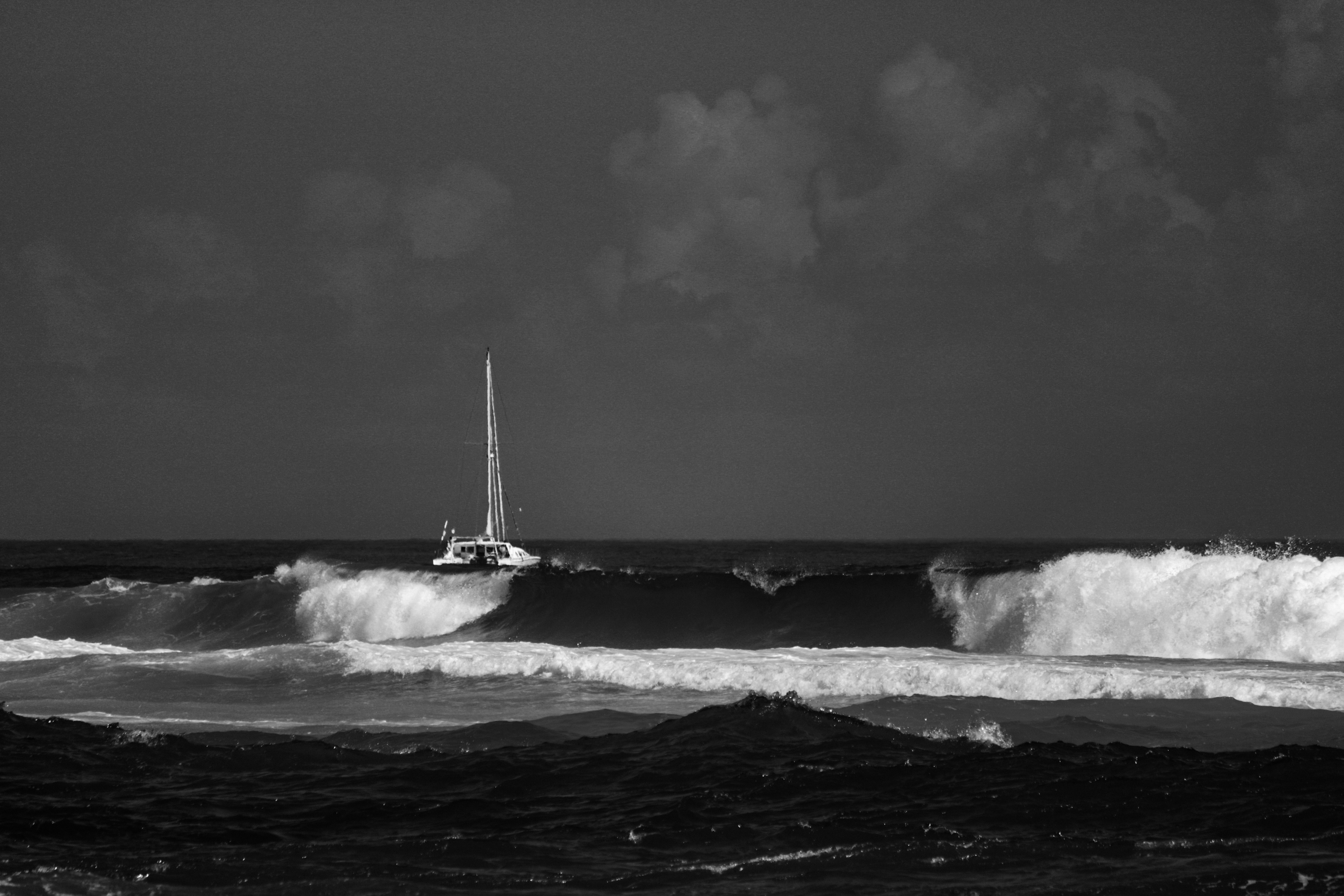 Uma foto preto e branco de um veleiro no oceano