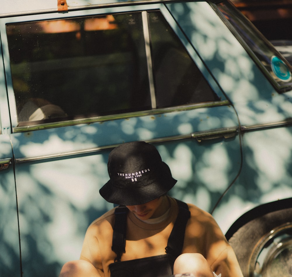 man in black cap and orange tank top