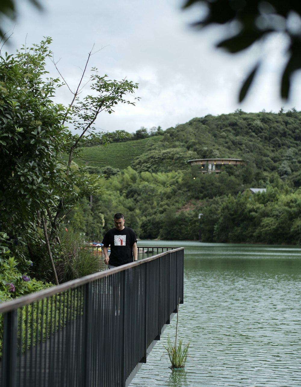 woman in black jacket and black pants standing on wooden dock during daytime