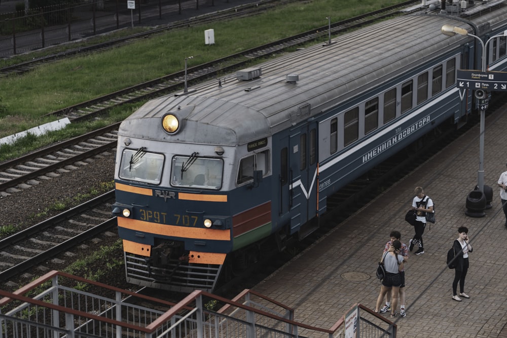 blau-grüner und roter Zug tagsüber auf Bahngleisen