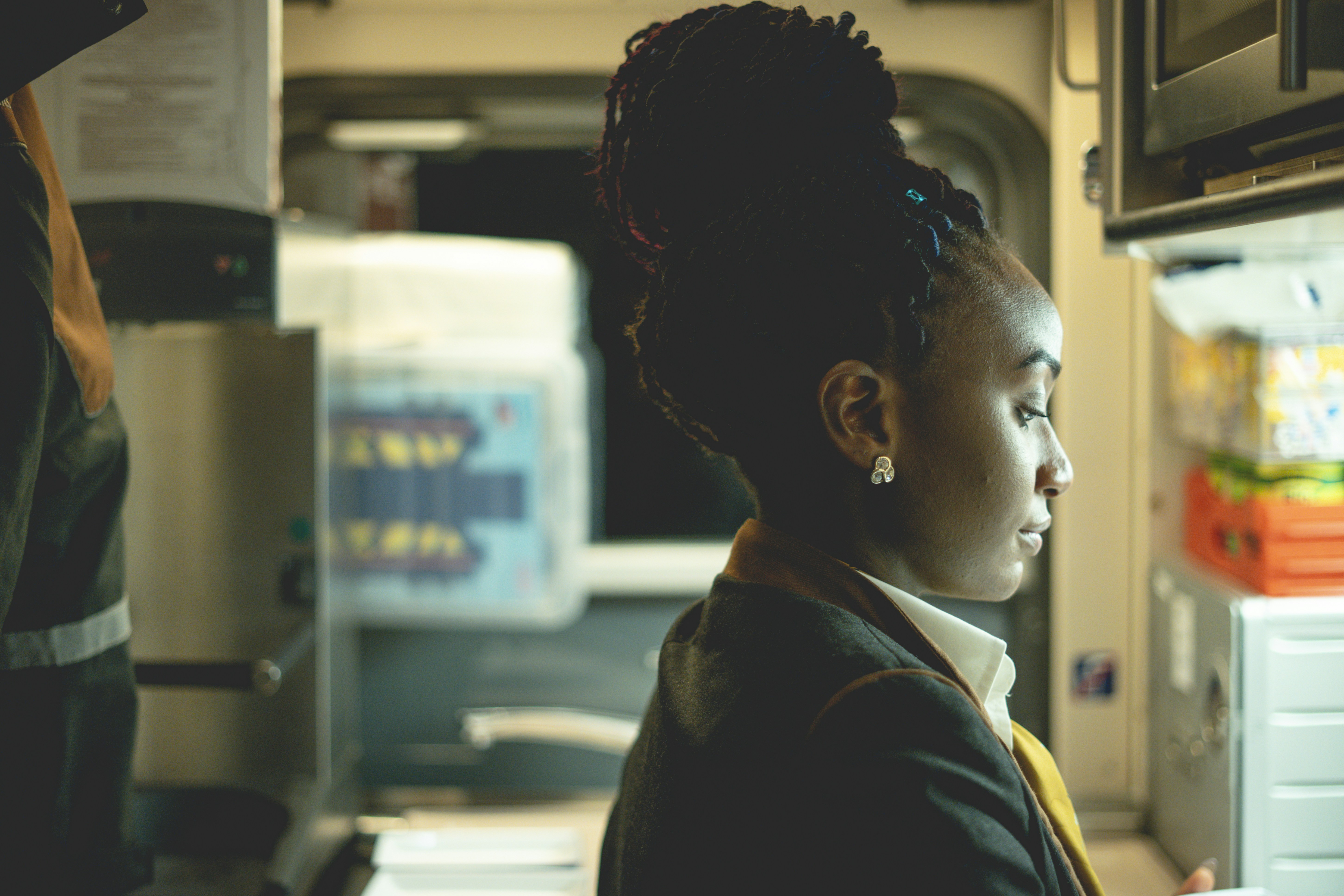 Mann im schwarzen Mantel steht neben weißer Maschine