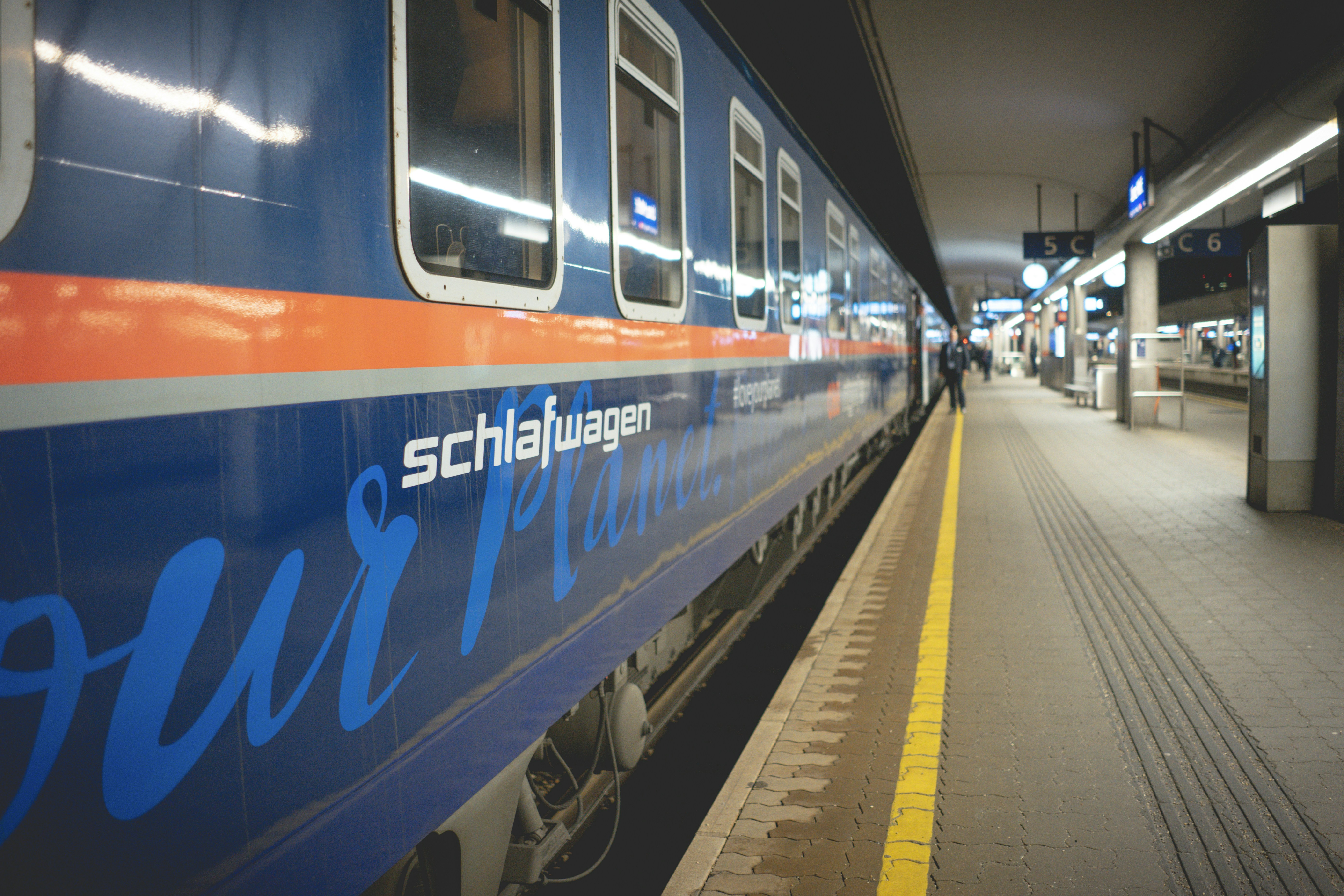 Blau-weißer Zug am Bahnhof