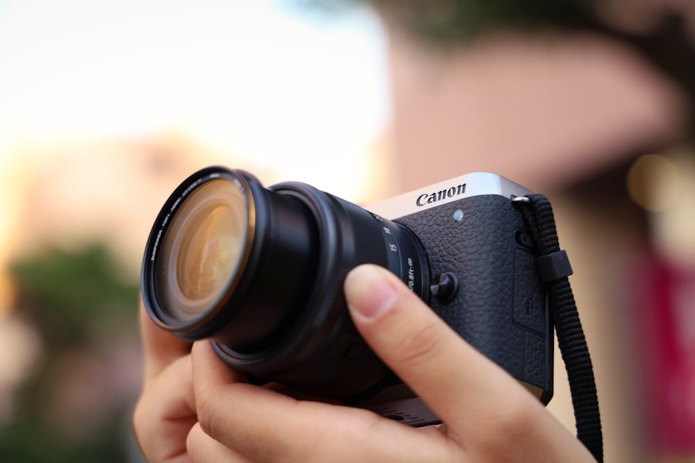 person holding black and silver nikon dslr camera