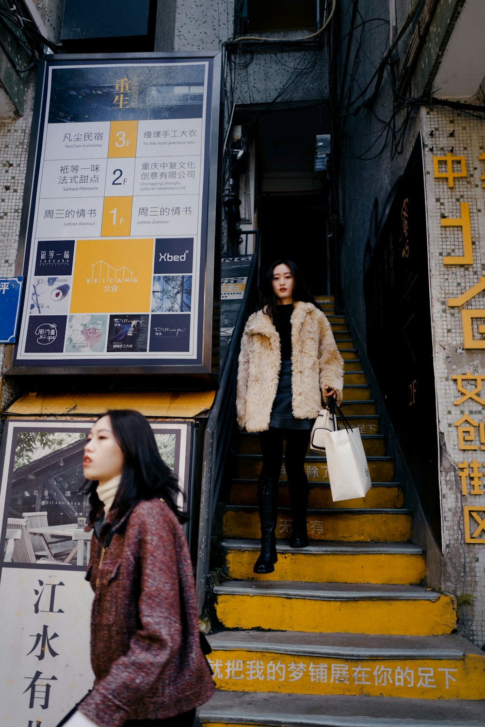 woman in brown coat standing beside black and brown wall