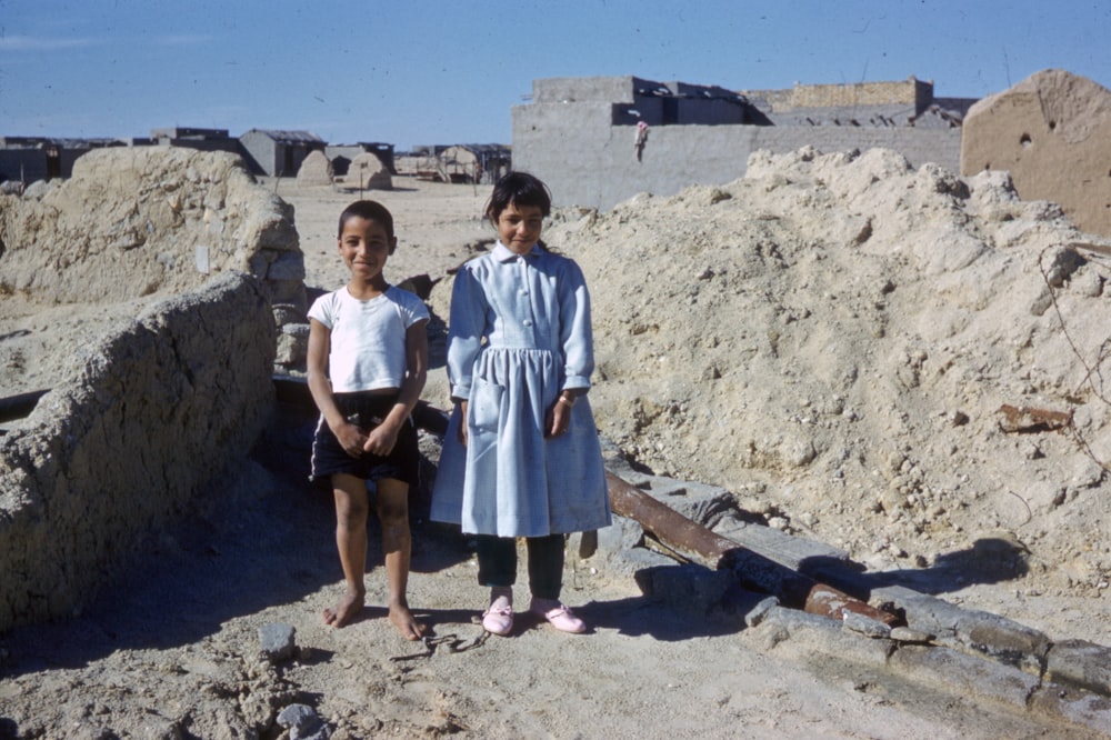 2 women standing on gray sand during daytime