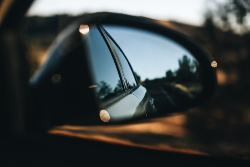 black car side mirror showing car
