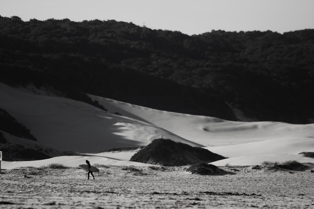 person walking on snow covered field during daytime