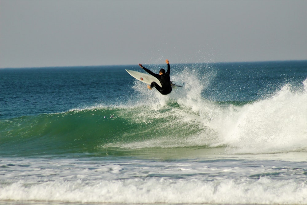 man surfing on sea waves during daytime