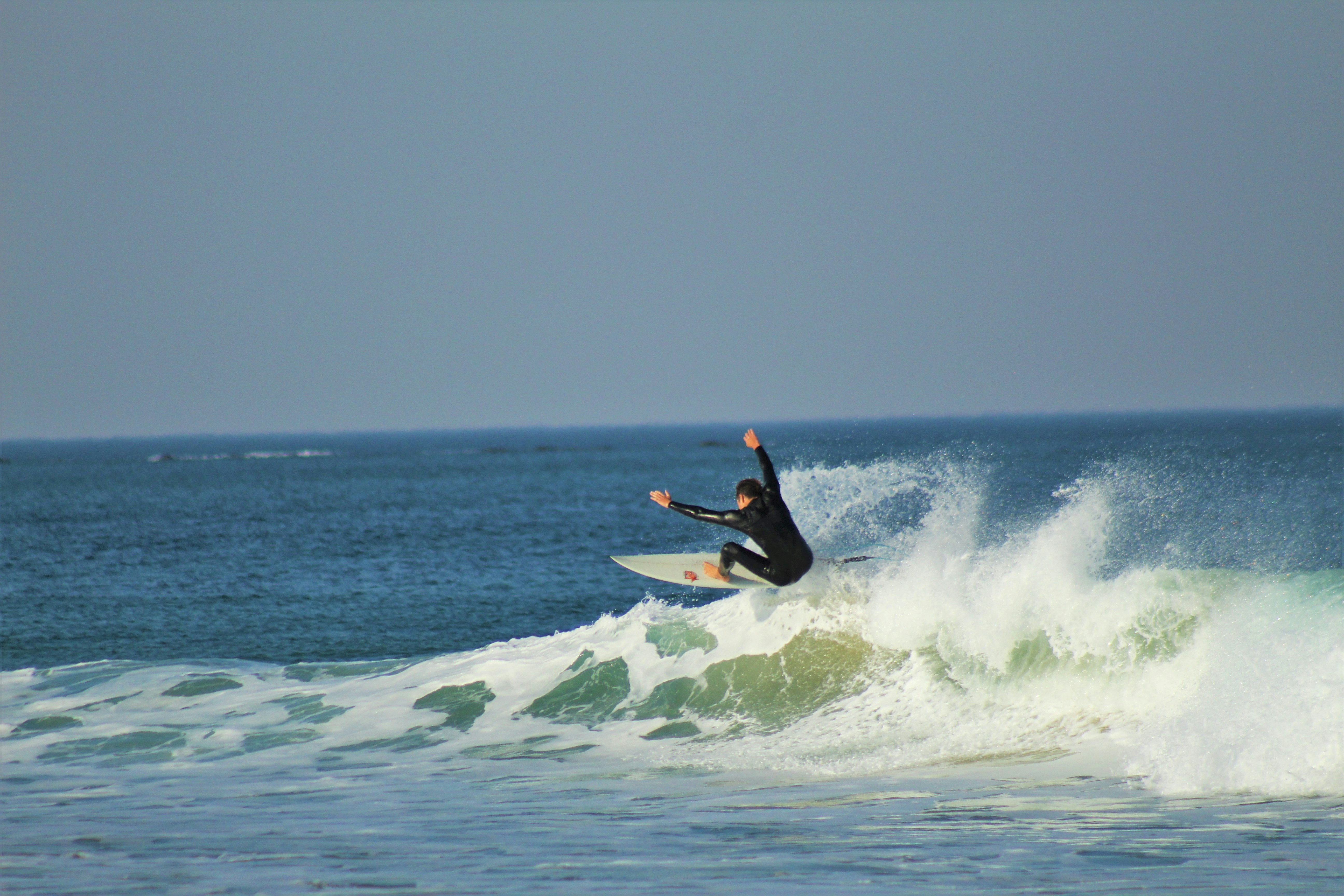 man surfing on sea waves during daytime