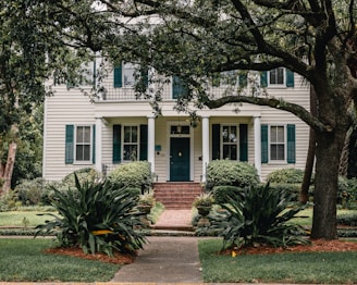 white wooden house near green trees during daytime