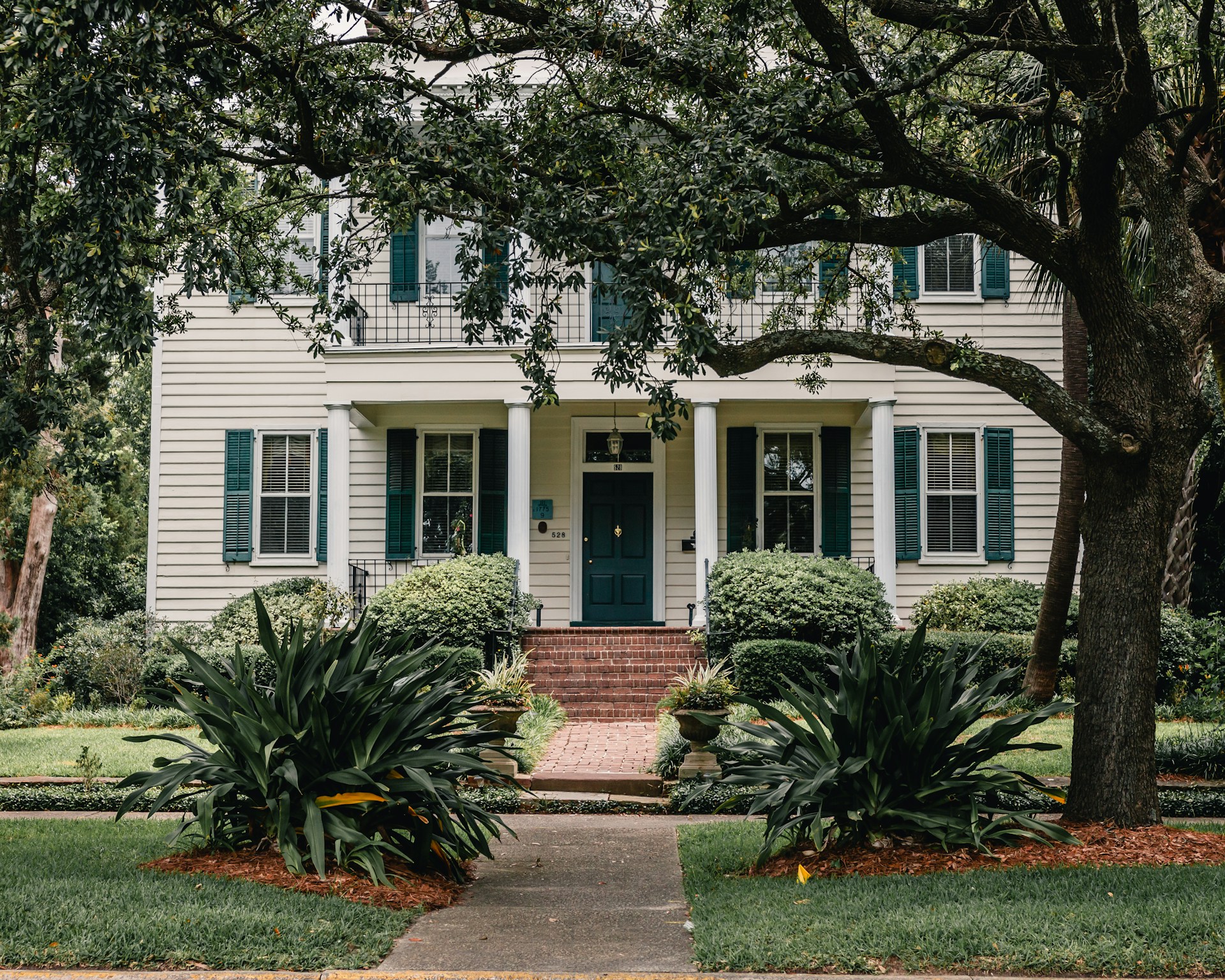 white wooden house near green trees during daytime