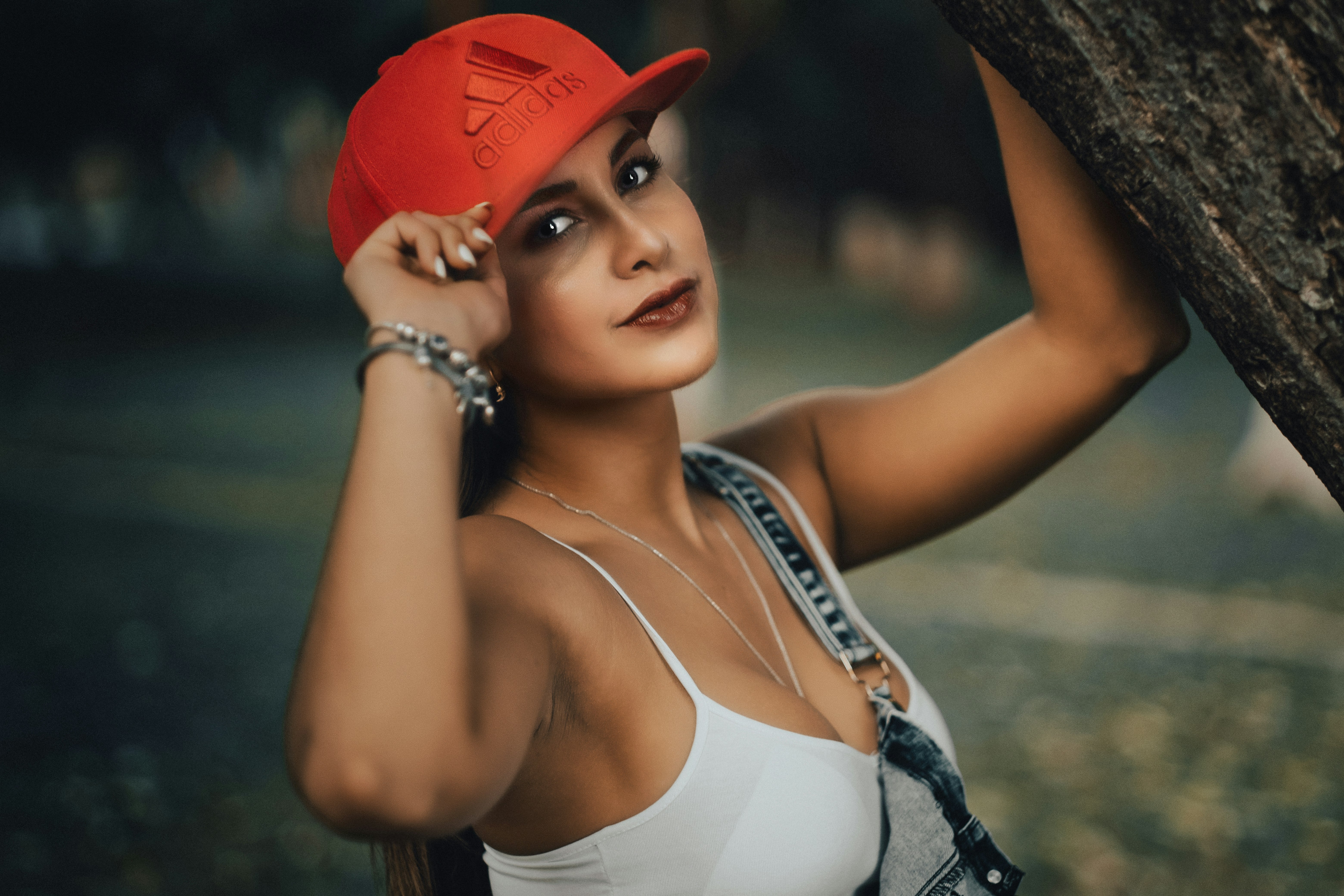 woman in white tank top and red cap