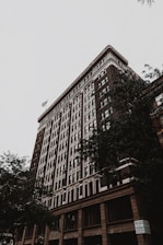 A stately, historic building with classic brickwork and an American flag waving gently in front.