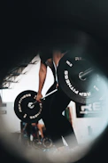 An athlete performing powerful weightlifting in a modern gym space.