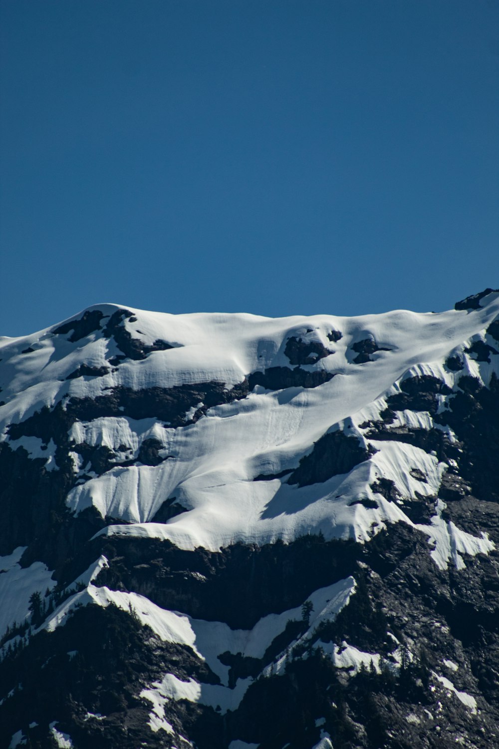 snow covered mountain under blue sky during daytime