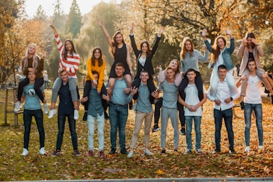 photography poses for big groups,how to photograph friends; group of people standing on green grass field