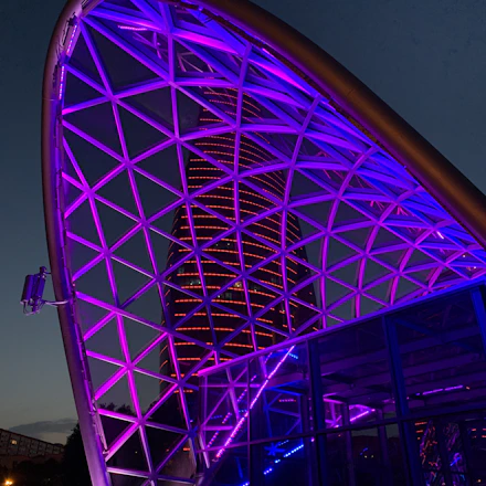 Futuristic cityscape with adaptive façade lighting and AI-driven energy systems glowing at dusk.