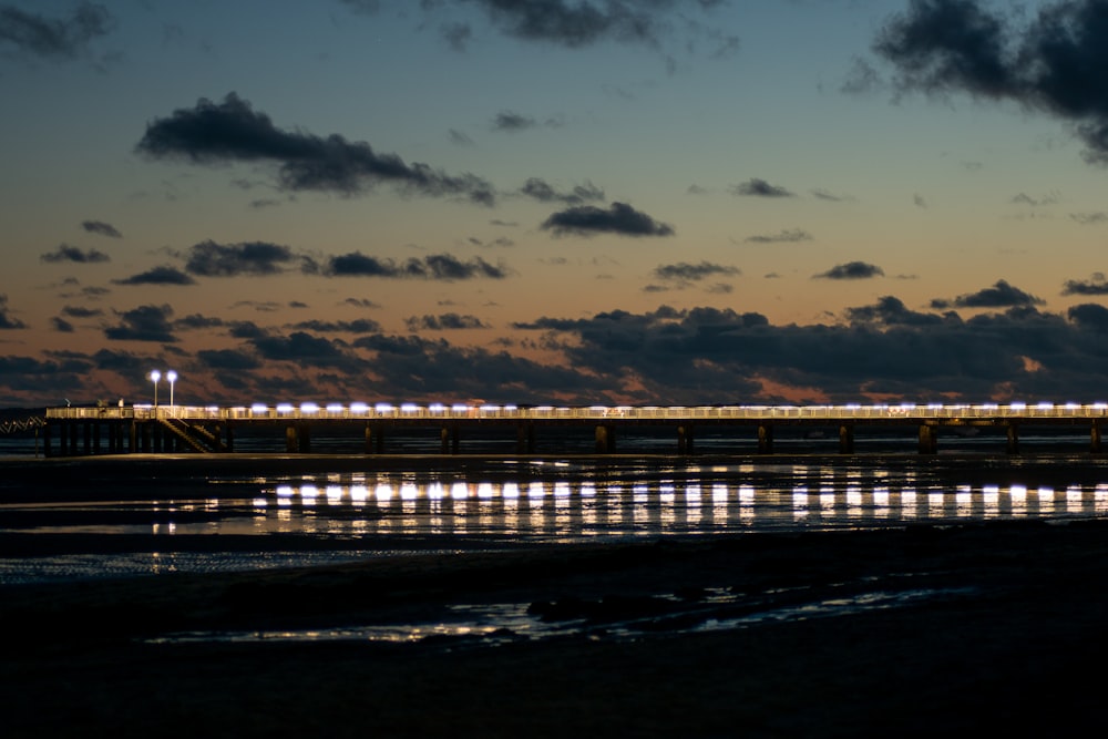 Quai en bois brun sur mer sous un ciel nuageux bleu et blanc pendant la journée