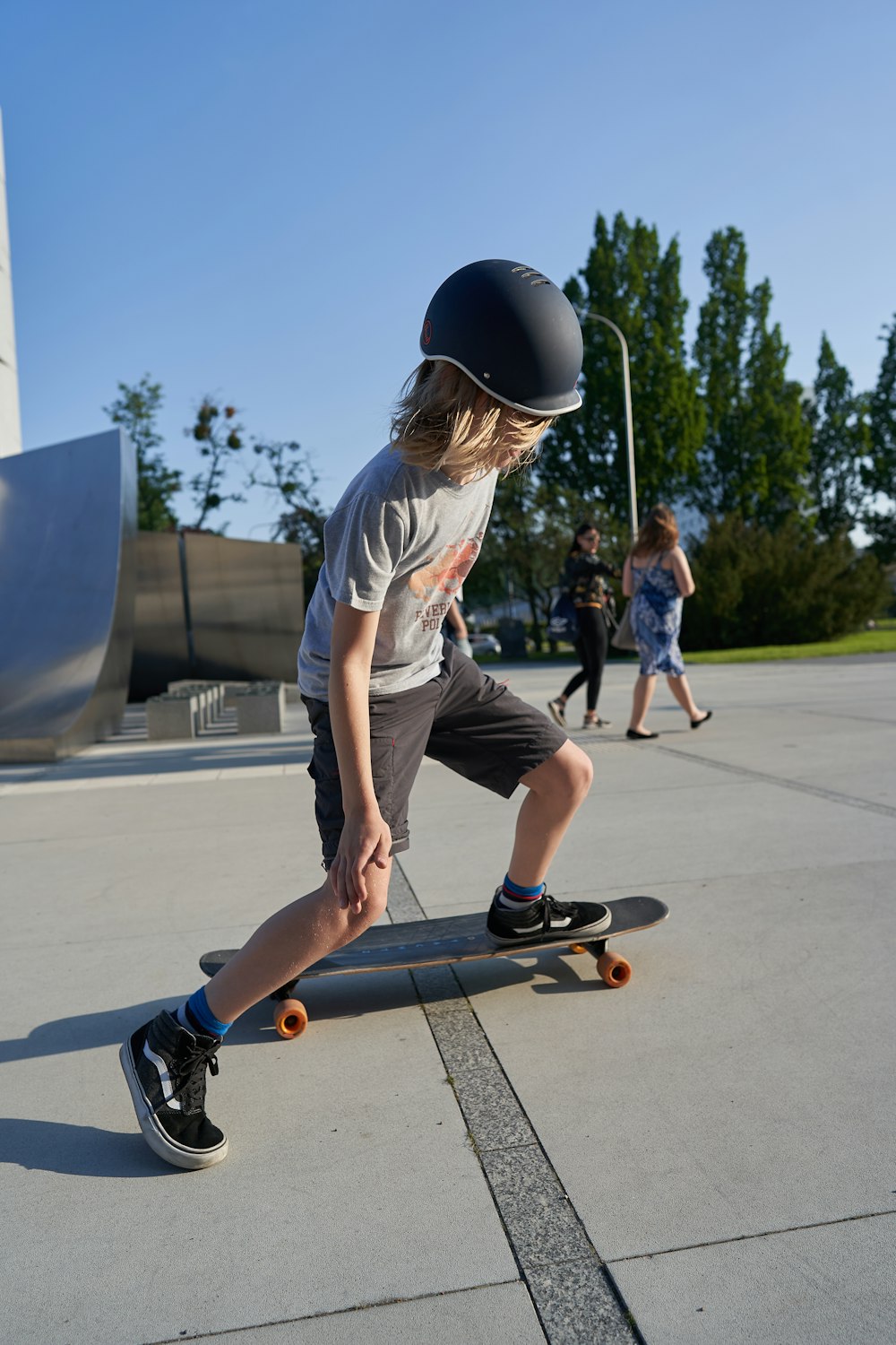 man in gray t-shirt and black shorts playing skateboard during daytime
