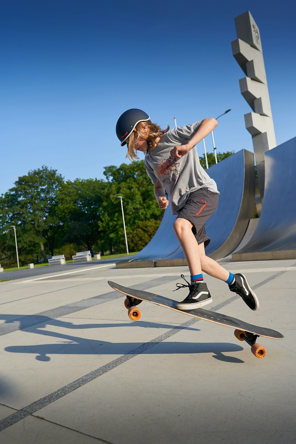 man in white t-shirt and black shorts riding skateboard during daytime