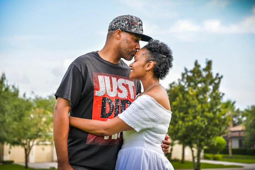 man in black crew neck t-shirt kissing woman in white dress