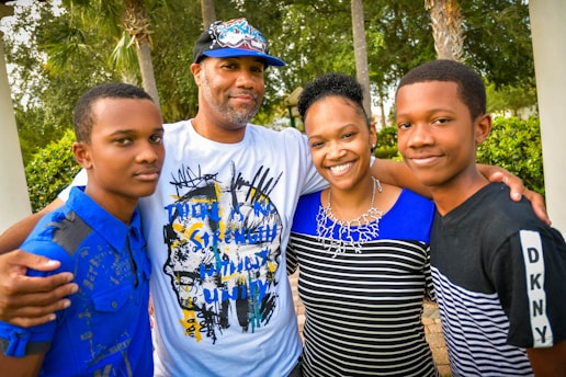 A happy family standing in front of their new home with keys in hand.