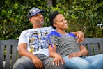 man in white crew neck t-shirt sitting beside woman in black and white stripe shirt