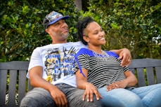 man in white crew neck t-shirt sitting beside woman in black and white stripe shirt