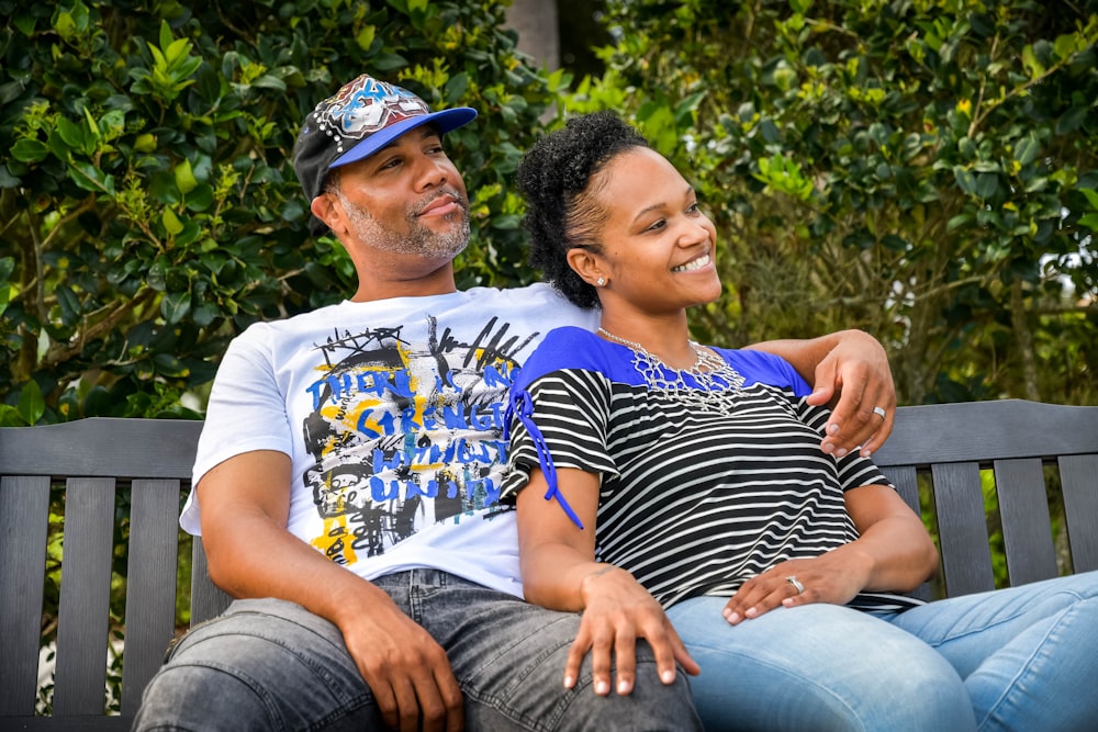 man in white crew neck t-shirt sitting beside woman in black and white stripe shirt