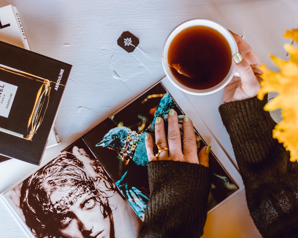 person holding white ceramic mug with coffee