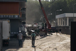 Crane lifting heavy materials at a busy construction site.
