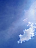 A large fluffy cloud is floating in a bright blue sky. The cloud has a soft, white texture with slightly irregular edges, set against a clear backdrop.