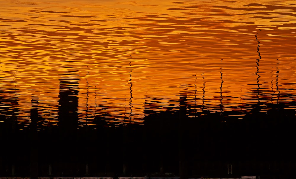 silhouette of body of water during sunset