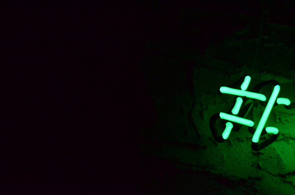 Signalisation lumineuse au néon vert sur le mur