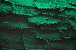 Close-up of textured eco-friendly bricks with a subtle green tint reflecting the brand's identity