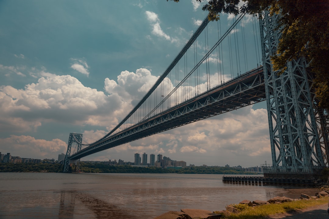 gray bridge under blue sky and white clouds during daytime