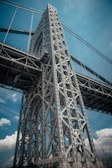 A panoramic view of a massive bridge under construction, showcasing sturdy steel frameworks against a clear blue sky.