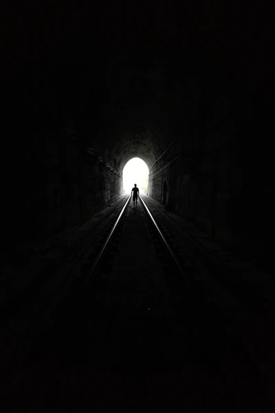 grayscale photo of tunnel with light