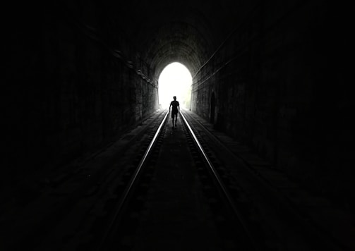 grayscale photo of tunnel with light