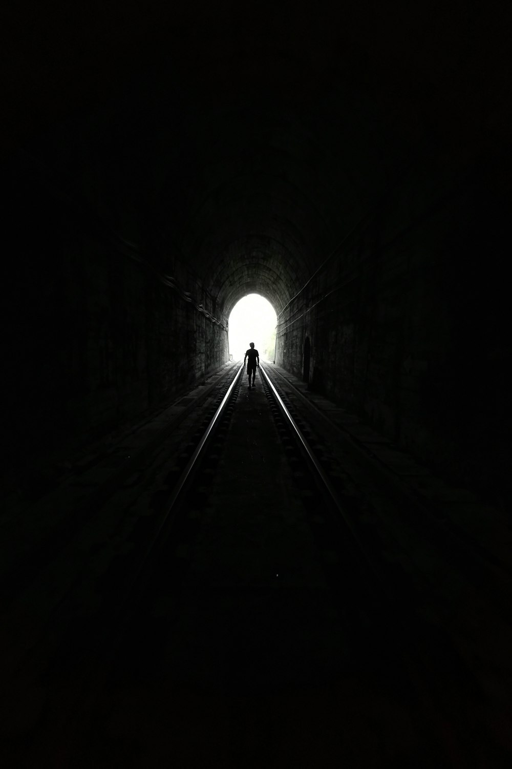 grayscale photo of tunnel with light