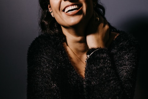smiling woman in black fur coat