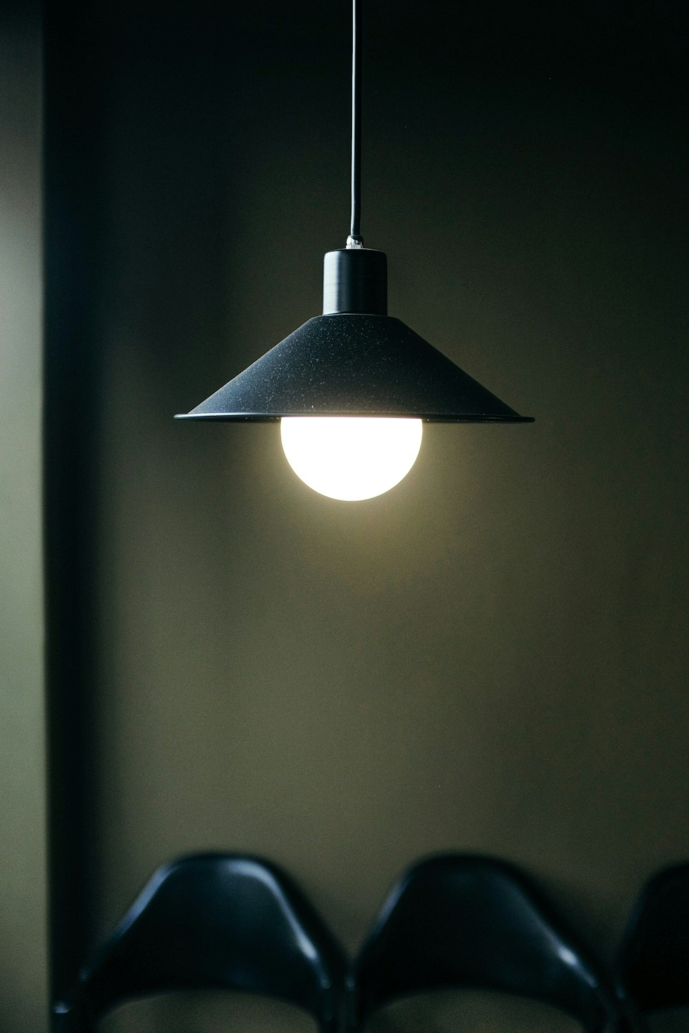 lampada a sospensione nera accesa in camera