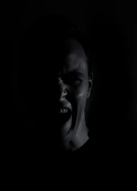 A close-up of a realistic 3D animated character expressing deep emotion in a dimly lit environment.