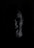 A partially illuminated face of a person in the dark, displaying an expression of anger or frustration with open mouth and furrowed brow. The surrounding darkness emphasizes the intensity of the emotion.