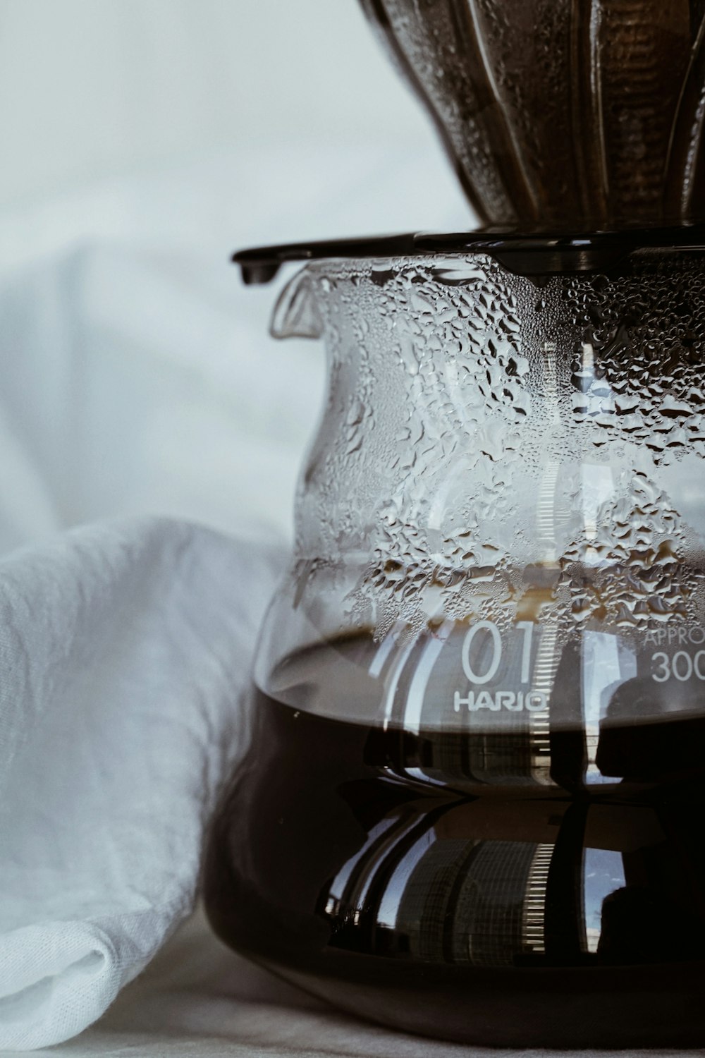 clear glass pitcher on white textile