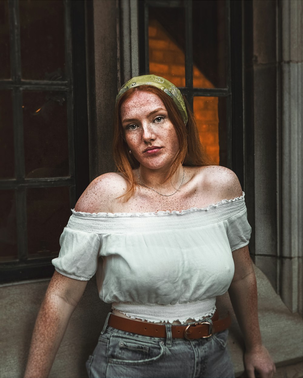 woman in white off shoulder shirt and yellow hat standing near brown wooden door