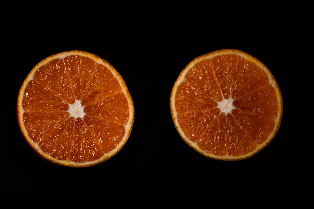 fruta laranja fatiada no fundo preto